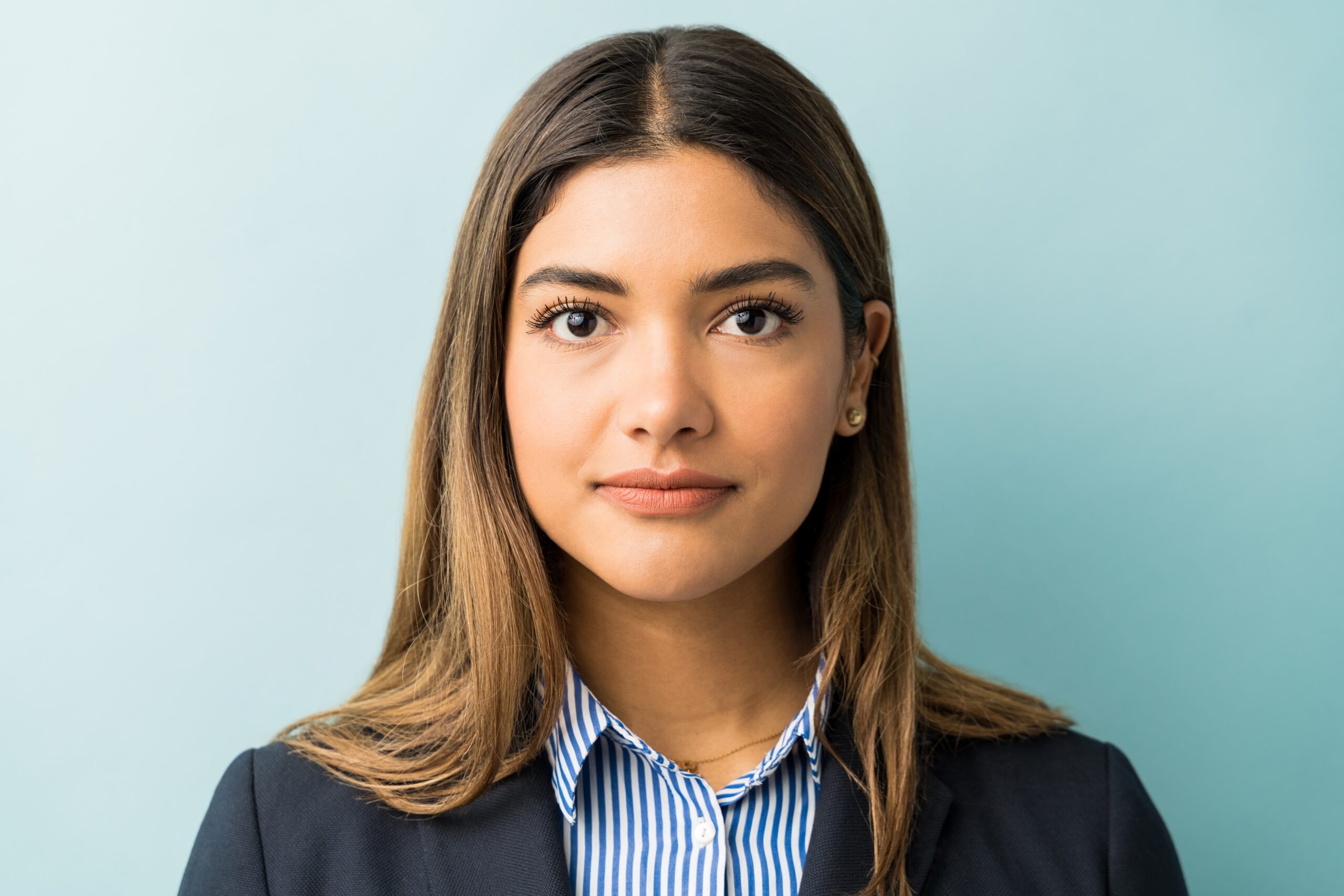 closeup-young-female-professional-making-eye-contact-against-colored-background-min closeup-young-female-professional-making-eye-contact-against-colored-background-min